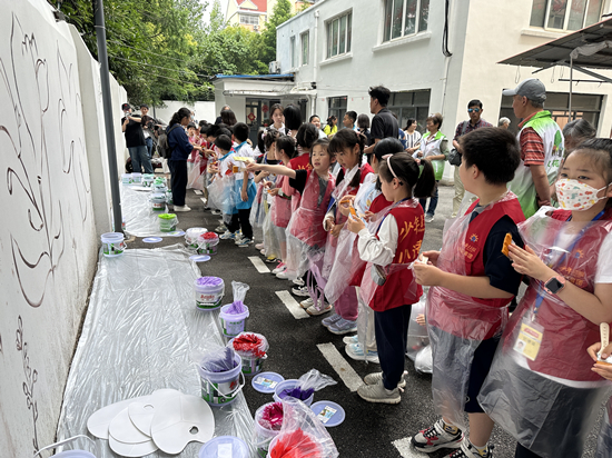 六一在这个陆家嘴小区艺术家和孩子一同将大自然保护植物画到墙上(图2)